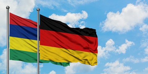 Mauritius and Germany flag waving in the wind against white cloudy blue sky together. Diplomacy concept, international relations.