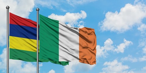 Mauritius and Ireland flag waving in the wind against white cloudy blue sky together. Diplomacy concept, international relations.