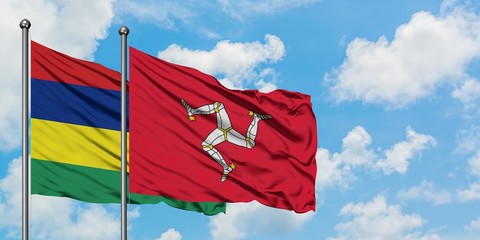 Mauritius and Isle Of Man flag waving in the wind against white cloudy blue sky together. Diplomacy concept, international relations.