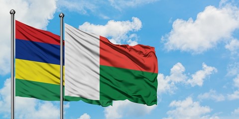 Mauritius and Madagascar flag waving in the wind against white cloudy blue sky together. Diplomacy concept, international relations.