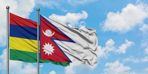 Mauritius and Nepal flag waving in the wind against white cloudy blue sky together. Diplomacy concept, international relations.