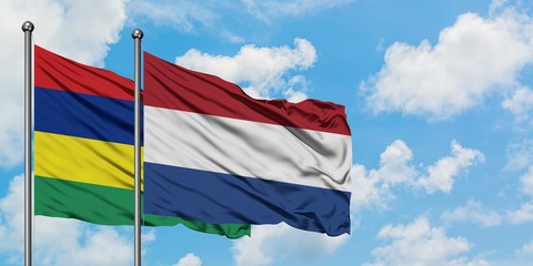 Mauritius and Netherlands flag waving in the wind against white cloudy blue sky together. Diplomacy concept, international relations.