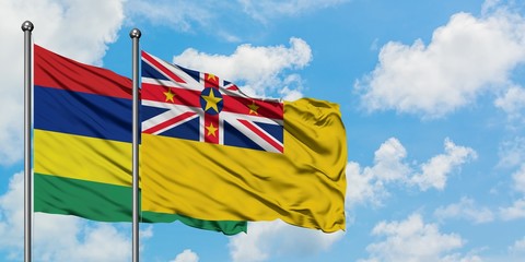 Mauritius and Niue flag waving in the wind against white cloudy blue sky together. Diplomacy concept, international relations.