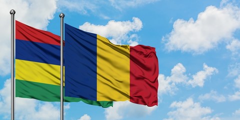 Mauritius and Romania flag waving in the wind against white cloudy blue sky together. Diplomacy concept, international relations.