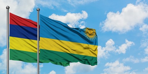 Mauritius and Rwanda flag waving in the wind against white cloudy blue sky together. Diplomacy concept, international relations.
