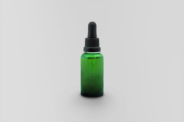 Empty green glass dropper for essential oil and cosmetic products isolated on soft gray background