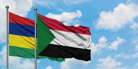 Mauritius and Sudan flag waving in the wind against white cloudy blue sky together. Diplomacy concept, international relations.