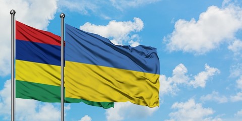 Mauritius and Ukraine flag waving in the wind against white cloudy blue sky together. Diplomacy concept, international relations.