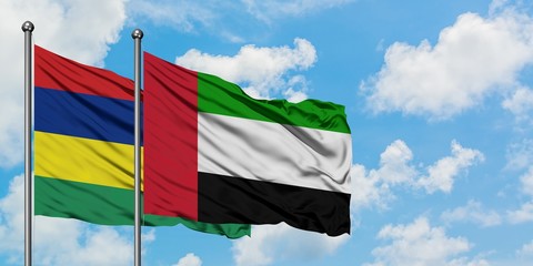 Mauritius and United Arab Emirates flag waving in the wind against white cloudy blue sky together. Diplomacy concept, international relations.