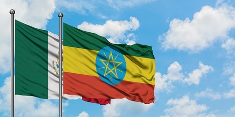 Mexico and Ethiopia flag waving in the wind against white cloudy blue sky together. Diplomacy concept, international relations.