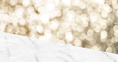 Empty white marbker angle table top with blur sparkling gold bokeh abstract background,panoramic...