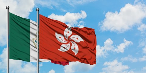 Mexico and Hong Kong flag waving in the wind against white cloudy blue sky together. Diplomacy concept, international relations.