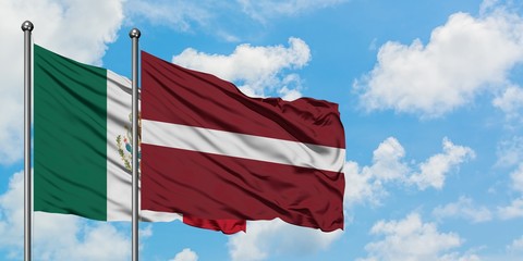 Mexico and Latvia flag waving in the wind against white cloudy blue sky together. Diplomacy concept, international relations.