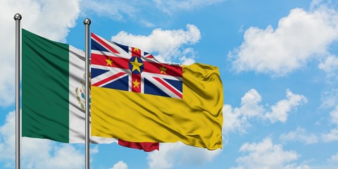 Mexico and Niue flag waving in the wind against white cloudy blue sky together. Diplomacy concept, international relations.