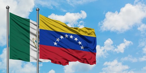 Mexico and Venezuela flag waving in the wind against white cloudy blue sky together. Diplomacy concept, international relations.