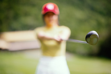 The young golfer blurred the image to capture the size of the driver of the club, protruding, focusing on the golf club head.