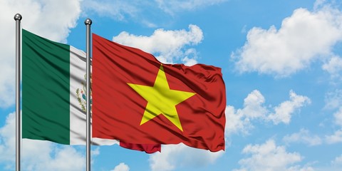 Mexico and Vietnam flag waving in the wind against white cloudy blue sky together. Diplomacy concept, international relations.