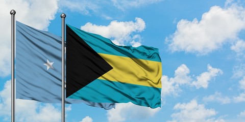 Micronesia and Bahamas flag waving in the wind against white cloudy blue sky together. Diplomacy concept, international relations.