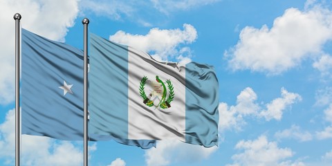 Micronesia and Guatemala flag waving in the wind against white cloudy blue sky together. Diplomacy concept, international relations.