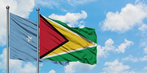 Micronesia and Guyana flag waving in the wind against white cloudy blue sky together. Diplomacy concept, international relations.