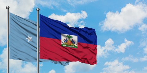 Micronesia and Haiti flag waving in the wind against white cloudy blue sky together. Diplomacy concept, international relations.