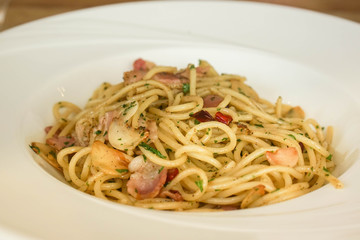 selective close up spicy seafood spaghetti in white plate for serving customers