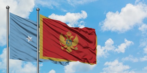 Micronesia and Montenegro flag waving in the wind against white cloudy blue sky together. Diplomacy concept, international relations.