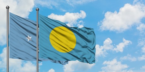 Micronesia and Palau flag waving in the wind against white cloudy blue sky together. Diplomacy concept, international relations.