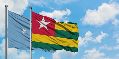 Micronesia and Togo flag waving in the wind against white cloudy blue sky together. Diplomacy concept, international relations.