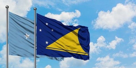 Micronesia and Tokelau flag waving in the wind against white cloudy blue sky together. Diplomacy concept, international relations.