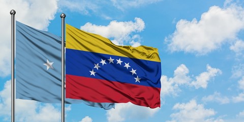 Micronesia and Venezuela flag waving in the wind against white cloudy blue sky together. Diplomacy concept, international relations.