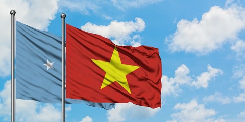 Micronesia and Vietnam flag waving in the wind against white cloudy blue sky together. Diplomacy concept, international relations.