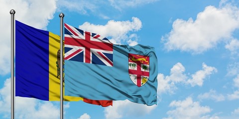 Moldova and Fiji flag waving in the wind against white cloudy blue sky together. Diplomacy concept, international relations.