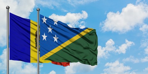 Moldova and Solomon Islands flag waving in the wind against white cloudy blue sky together. Diplomacy concept, international relations.