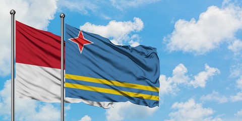 Monaco and Aruba flag waving in the wind against white cloudy blue sky together. Diplomacy concept, international relations.