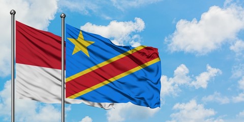 Monaco and Congo flag waving in the wind against white cloudy blue sky together. Diplomacy concept, international relations.