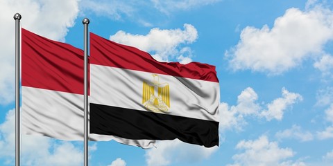 Monaco and Egypt flag waving in the wind against white cloudy blue sky together. Diplomacy concept, international relations.