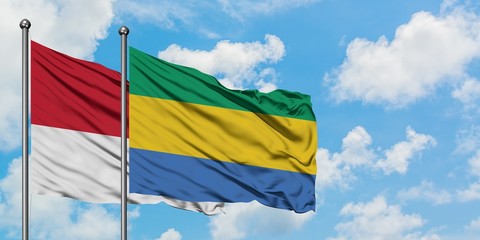 Monaco and Gabon flag waving in the wind against white cloudy blue sky together. Diplomacy concept,...