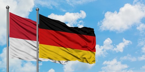Monaco and Germany flag waving in the wind against white cloudy blue sky together. Diplomacy concept, international relations.