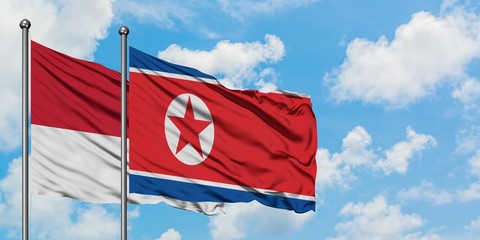 Monaco and North Korea flag waving in the wind against white cloudy blue sky together. Diplomacy concept, international relations.