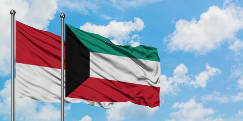 Monaco and Kuwait flag waving in the wind against white cloudy blue sky together. Diplomacy concept, international relations.