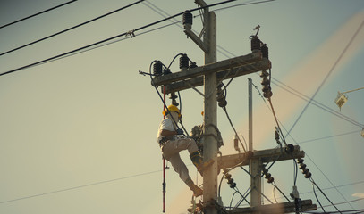 technician work on high voltage electic pole with copy space