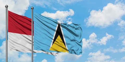 Monaco and Saint Lucia flag waving in the wind against white cloudy blue sky together. Diplomacy concept, international relations.