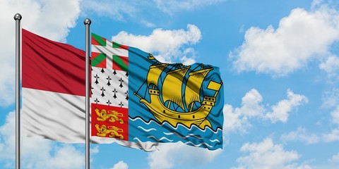 Monaco and Saint Pierre And Miquelon flag waving in the wind against white cloudy blue sky together. Diplomacy concept, international relations.