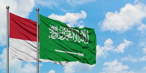Monaco and Saudi Arabia flag waving in the wind against white cloudy blue sky together. Diplomacy concept, international relations.