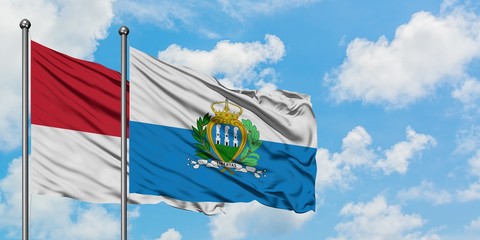 Monaco and San Marino flag waving in the wind against white cloudy blue sky together. Diplomacy concept, international relations.