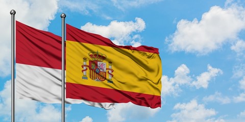Monaco and Spain flag waving in the wind against white cloudy blue sky together. Diplomacy concept, international relations.