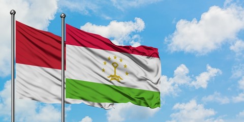 Monaco and Tajikistan flag waving in the wind against white cloudy blue sky together. Diplomacy concept, international relations.