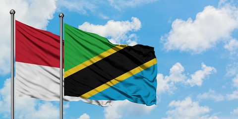 Monaco and Tanzania flag waving in the wind against white cloudy blue sky together. Diplomacy concept, international relations.