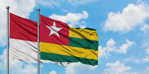 Monaco and Togo flag waving in the wind against white cloudy blue sky together. Diplomacy concept, international relations.